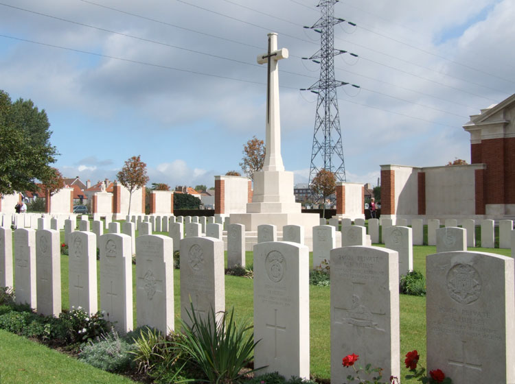 View of Dunkirk Town Cemetery with Private Smith's grave 5th from the right on the front row, and the Dunkirk Memorial in the background.